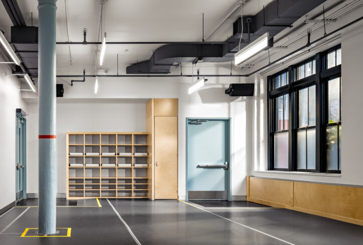 A dance studio with grey marley floor and one grey column towards one end of the room. Photo by Alexander Severin.