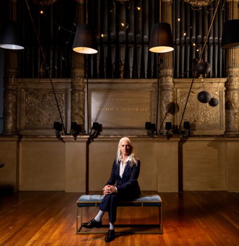 Portrait of KJ Holmes seated in front of the altar at the Judson Memorial Church. Photo by Rachel Keane.