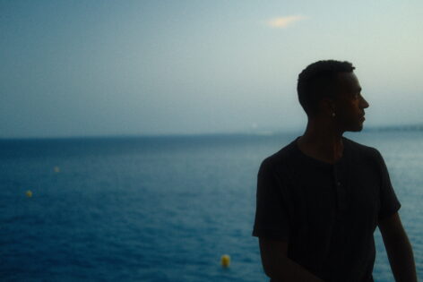 The subject in the foreground is shadowed profile in front of a blue ocean background and misty blue sky. Photo by Rudy Gerson.