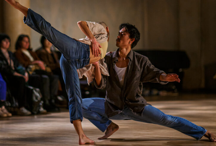 KAŌS Dance Collective performing for Movement Research at the Judson Church. One dancer is in a deep lunge supporting another dancer who leans towards them for support while performing an arabesque. Photo by Rachel Keane.