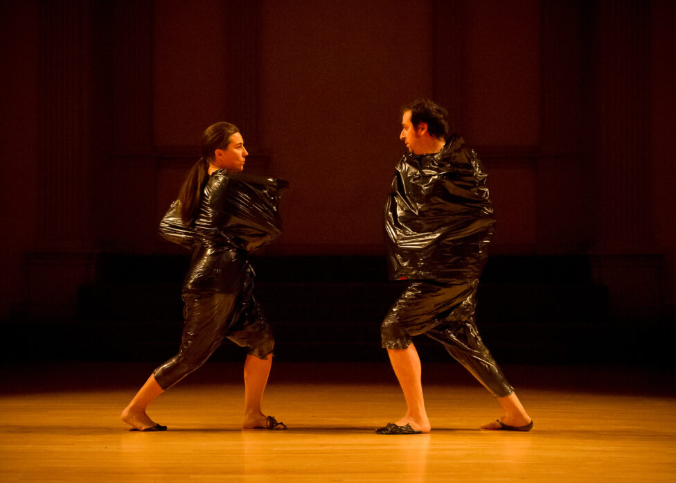 Photo from the MR Festical 2012. luciana achugar and Levy Gonzalez move towards each other. They are wrapped in black plastic bags. photo by Ian Douglas
