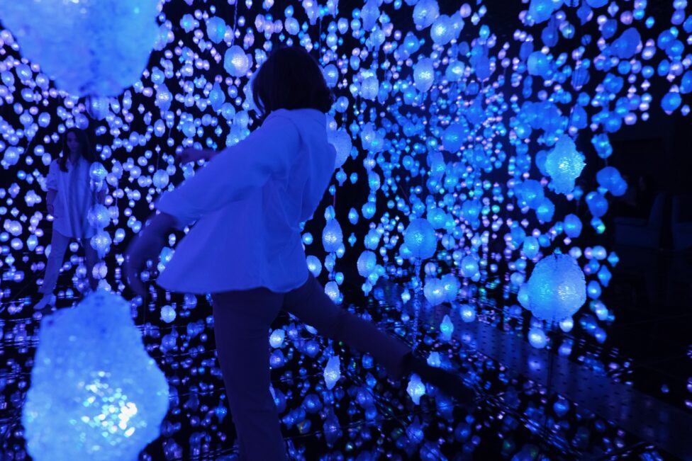 Tatiana in movement in the a dimly lit and immersive lights installation by Pipilotti Rist titled Your Brain to Me, My Brain to You at the Qatar National Museum. Photo courtesy of the artist.