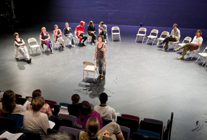 A semi circle of chairs and one person in the center of a theater. Participants engage with the discussion. From the MR Archives. 2010.10.28.Moving Dialogue.Vava Stefanescu. Photo by Ian Douglas.