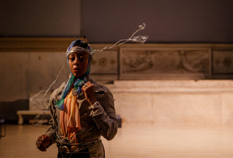 Fana Fraser performing for Movement Research at the Judson Church. Fana looks into the camera wearing a silver wire headdress. Photo by Rachel Keane.