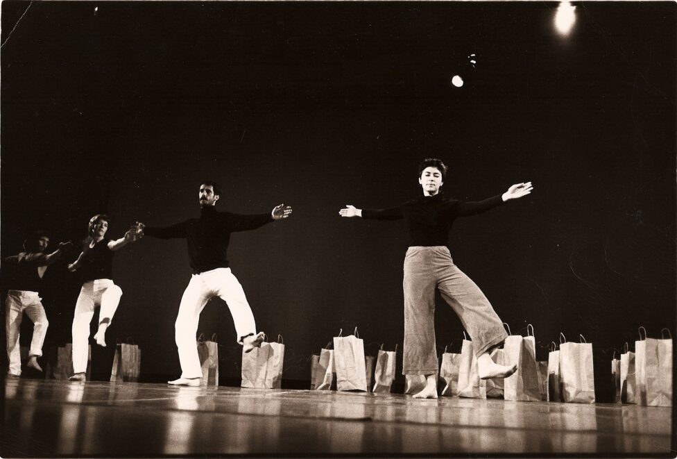 4 performers on a stage in black tops and light pants open their arms wide and balance on one leg facing forward. 1980 From the Archives. MR Benefit photo by-Nathaniel Tileston.