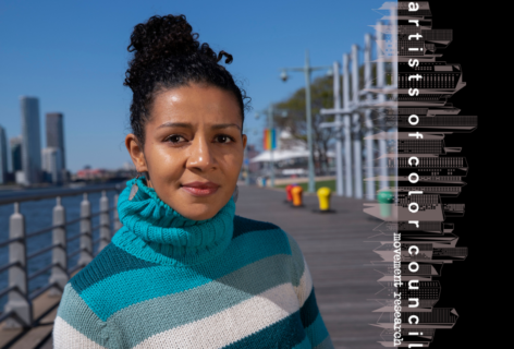 Graphic with an image of Maria Bauman and the AoCC logo. Maria Bauman looks into the camera wearing a blue stripped turtleneck sweater and her curly hair in a top bun. Photo by Lola Flash.