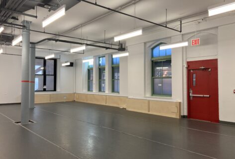 A photo of the new studio at 122CC. An empty studio with grey marly and bright fluorescent lights. Photo by Raychel Ceciro.