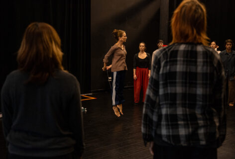 From the MR Archives; 2024.07.12. Summer MELT. Shelly Senter. Photo by Rachel Keane. Shelley mid air with her hands behind her back, students watch her in action.