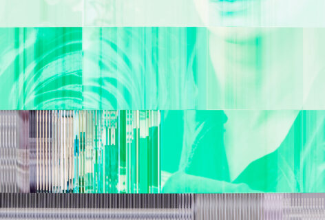 a digital photo that has a datamosh quality to it. The face of Laurel is featured mostly in shades of green, and the pixels seem to jam and striate up against one another as if the photo has been chiseled into the side of a mountain. Her arms appear at the bottom of the photo, the aspect of the image that can been seen as 