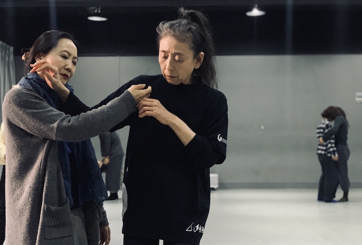 Eiko assists another in a class setting. Photo by Qian Min.