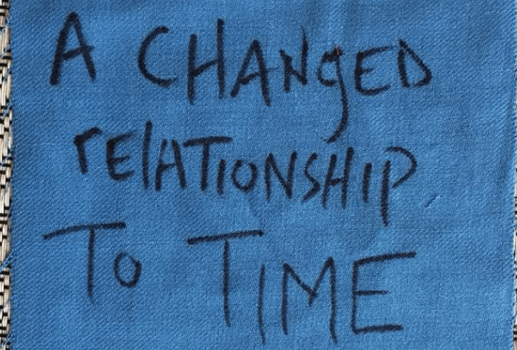 A hand-written message written in black marker appears on an indigo-blue fabric square. It reads,