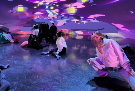 A group of dancers move in a dream journey in front of the Planting Disabled Futures tree world projection. Photo by Petra Kuppers.