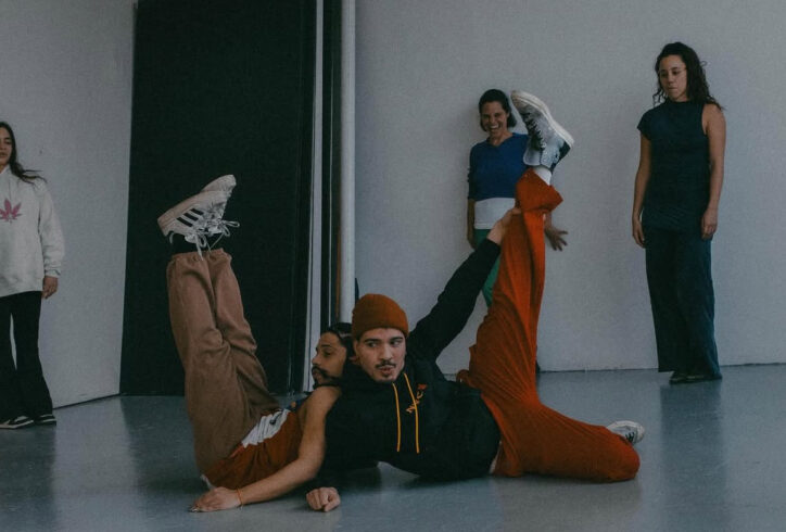A group of 5 dancers in various positions; 2 in the center on the floor with their legs up. Photo by Camila Falquez.