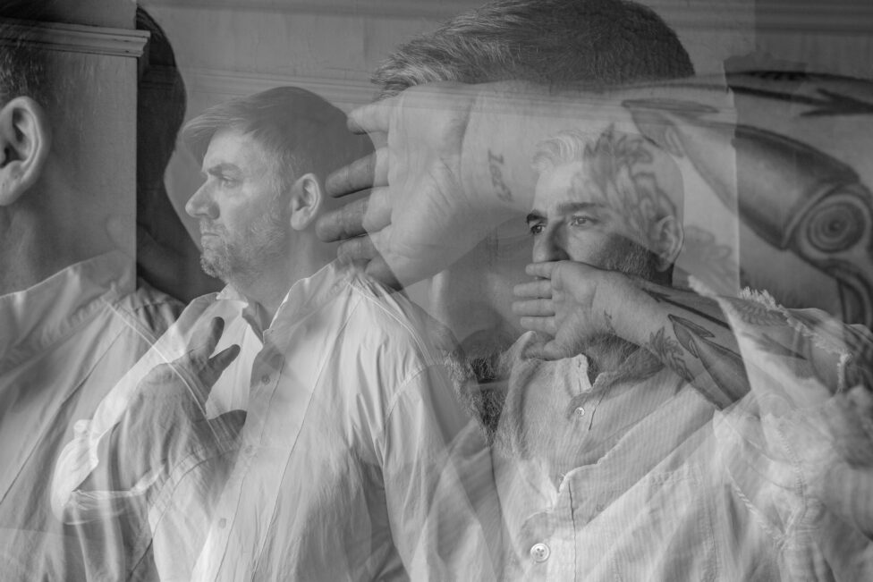 Black and white image of two men in white button downs face the left. Jon Kinzel and Fabio Tavares. Photo credit: Zach Gross