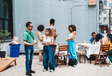 AoCC Cookout attendees are active in conversation, outside in courtyard space. Photo by Emily Farthing.