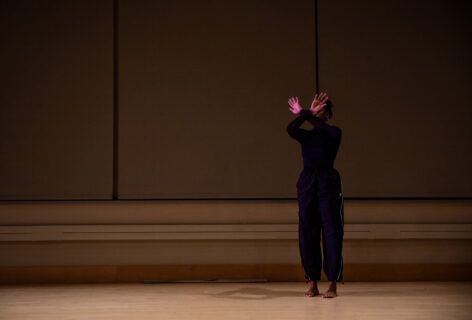 Angie Pittman crosses hands in front of face and standing on hardwood floor. Tech photo from BAM. Rachel Keane