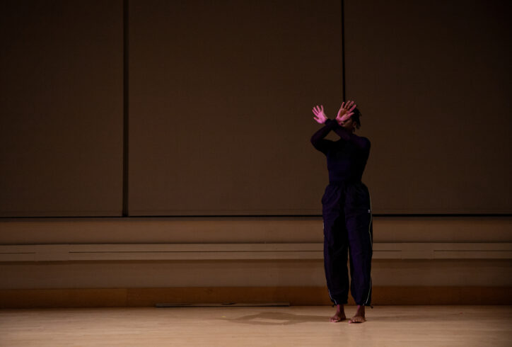 Angie Pittman crosses hands in front of face and standing on hardwood floor. Tech photo from BAM. Rachel Keane