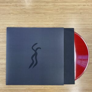 A red vinyl album peeks out of a gray-black record sleeve