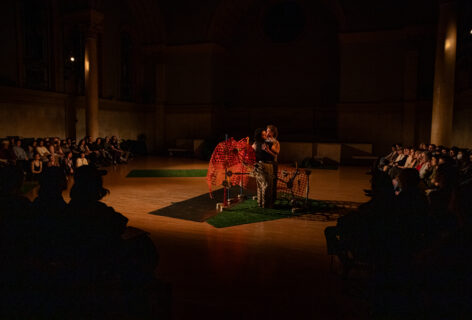 mik phillips + tor breen perform for Movement Research at the Judson Church. Two dancers embrace inside a structure made of assembled disparate objects. Photo by Rachel Keane.