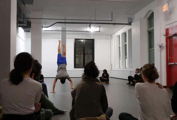 2019 Open Performance; audience members watching a dancer holds a handstand in the MR Studio. Photo by Harry Shunyao Zhang.