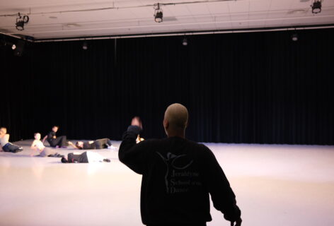 Alexis Diggs, back to the camera, in dialogue with artists during rehearsal in a black box studio at the Royal Conservatoire. Photo by Jan van de Putte.