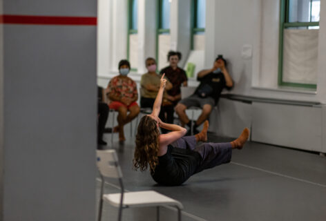 2022 Open Performance; a dancer sits on the floor pointing up and legs elevated. Photo by Rachel Keane.